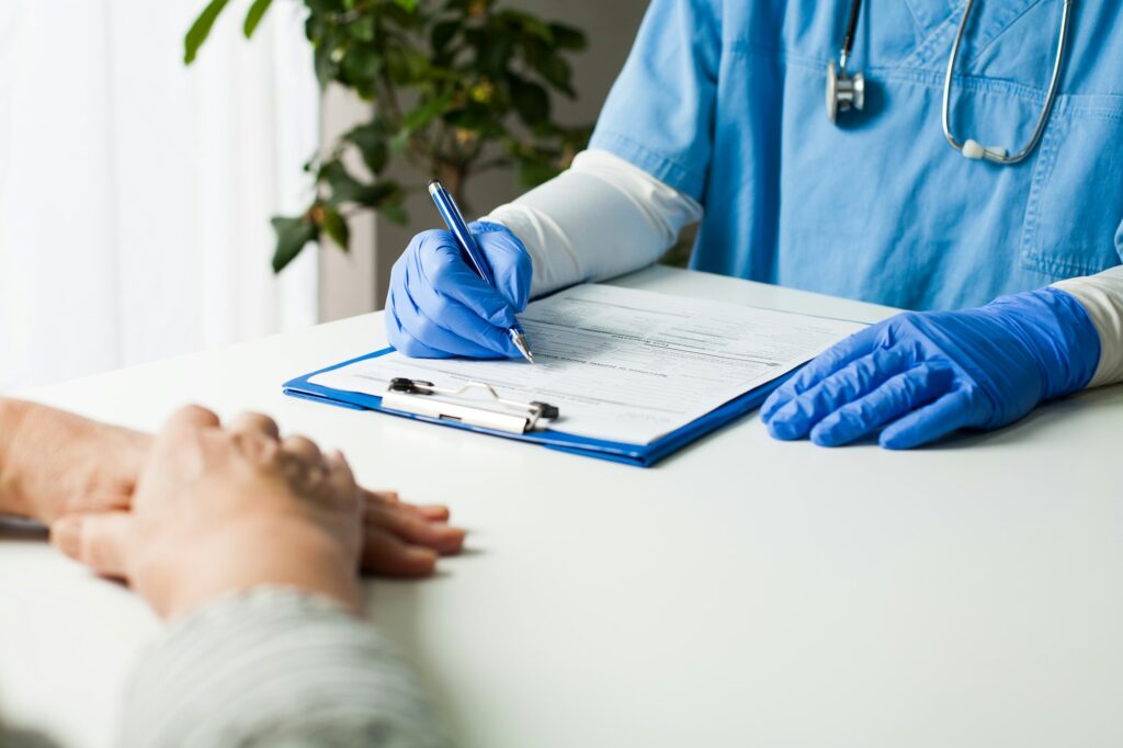 General Practitioner Completing Patient Examination In Doctor'S Office